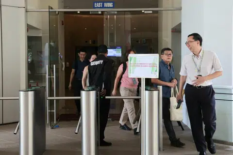 ISU KESELAMATAN: Orang ramai dilihat keluar dari Bangunan Sekitaran di 40 Scotts Road pada Rabu.