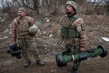 SENJATA CANGGIH: Seorang askar Ukraine (gambar atas) kelihatan membawa peluru berpandu antikereta kebal Javelin buatan Amerika. Turkey juga membekalkan dron jenis Bayraktar kepada Ukraine yang digunakan dengan penuh berkesan dalam perang Ukraine. - Foto-foto AFP, REUTERS