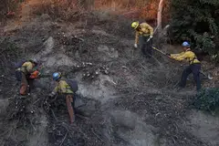Pasukan bomba membersihkan sampah sarap dan mematikan bara api sebagai langkah mencegah kebakaran daripada berulang akibat angin Santa Ana yang kembali bertiup di selatan California.