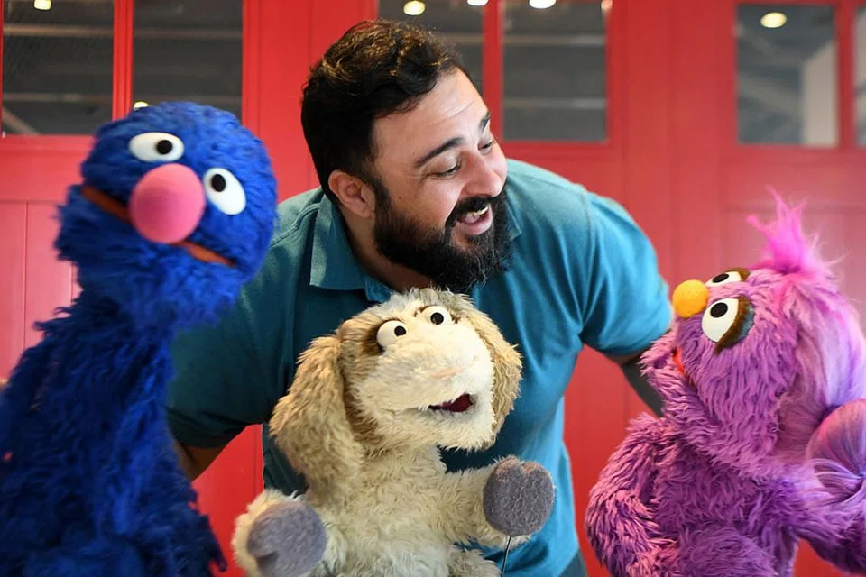 SUMBER PELBAGAI BAHASA: Hadi, nama watak yang dimainkan oleh pelakon Jordan, Rami Delshad, bergambar bersama Grover (Gargur dalam bahasa Arab) (kiri), Ma'zooza (tengah) and Basma (kanan) dari siri televisyen Sesame Street, di Dubai pada Januari lalu. - Foto AFP dan SESAME WORKSHOP