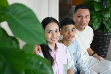Cik Izlin Ismail dan Encik Mohamed Huzaini bersama anak mereka, Hayden Anash, di Menara NUHS pada 26 Jun 2025. Hayden, pernah dikejarkan ke hospital ketika berusia tiga bulan selepas mengalami bengkak akibat minum susu tepung. Dia kemudian disahkan mengalami alahan terhadap susu, telur dan kacang tanah. Kini, Hayden menyertai kajian yang meneliti kesan alahan makanan terhadap kanak-kanak di Singapura.