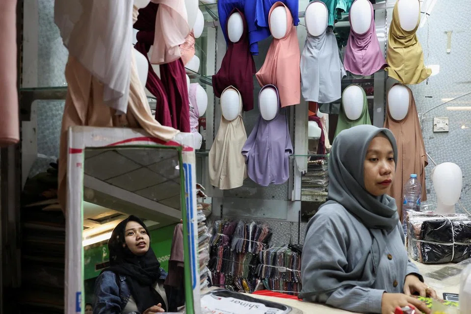 Para pengguna kini tidak lagi perlu bersua muka untuk membeli barang seperti yang dilakukan oleh seorang pelanggan dengan penjual semasa membeli-belah di pasar tekstil Tanah Abang di Jakarta, Indonesia, pada 5 Mac, sedang skim ‘beli sekarang, bayar nanti’ (BNPL) menawarkan pembelian dalam talian.