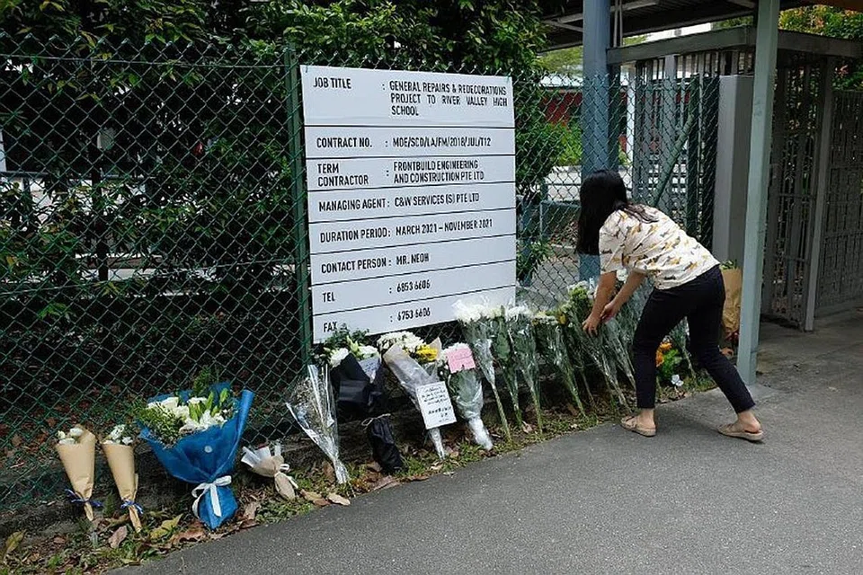 MANGSA DIPERINGATI: Beberapa jambak bunga dilihat diletakkan di luar pagar Sekolah Tinggi River Valley semalam. - Foto BH oleh JOYCE FANG