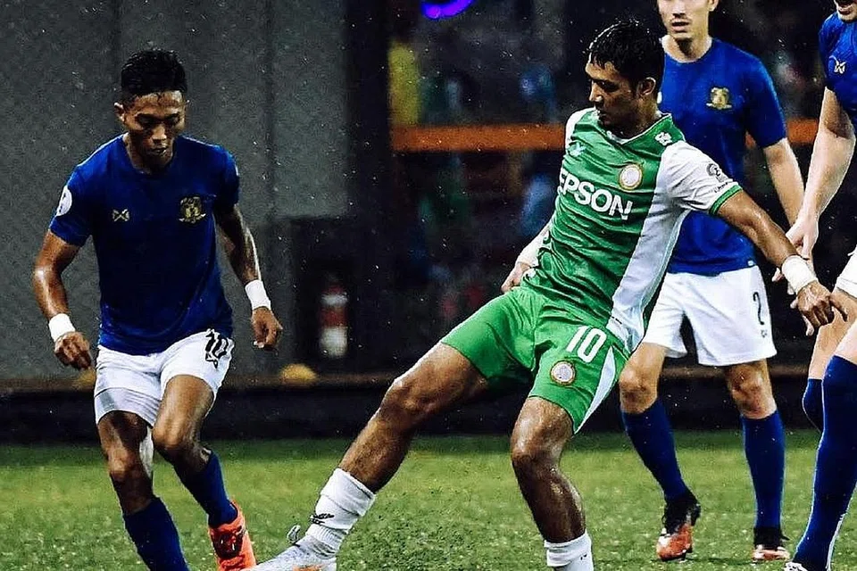 REBUT BOLA: Shawal Anuar (jersi biru) cuba merampas bola dari kaki pemain Geylang International Fareez Farhan. Geylang menewaskan Hougang 2-0 dalam perlawanan itu. - Foto SPL