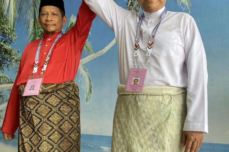 SALING MENGHORMATI: Menteri Besar Terengganu, Datuk Seri Dr Ahmad Samsuri Mokhtar (kanan), calon PN-PAS; dan Encik Suhaimi Sulaiman, calon Amanah, mengangkat tangan satu sama lain selepas menyerahkan borang pencalonan bagi DUN N19 Ru Rendang yang mereka tandingi di Pusat Penamaan Calon di Pejabat Daerah dan Tanah Marang pada pagi Sabtu.