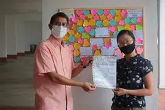 PUPUK SIFAT PERPADUAN: Dr Muhammad Faishal Ibrahim bersama pencetus inisiatif "Papan Notis Terima Kasih", Cik Jaslyne Chia, di Blok 745 Yishun Street 72. - Foto BH oleh JASON QUAH