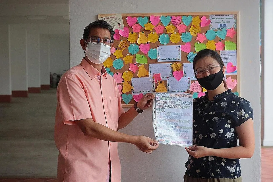 PUPUK SIFAT PERPADUAN: Dr Muhammad Faishal Ibrahim bersama pencetus inisiatif "Papan Notis Terima Kasih", Cik Jaslyne Chia, di Blok 745 Yishun Street 72. - Foto BH oleh JASON QUAH