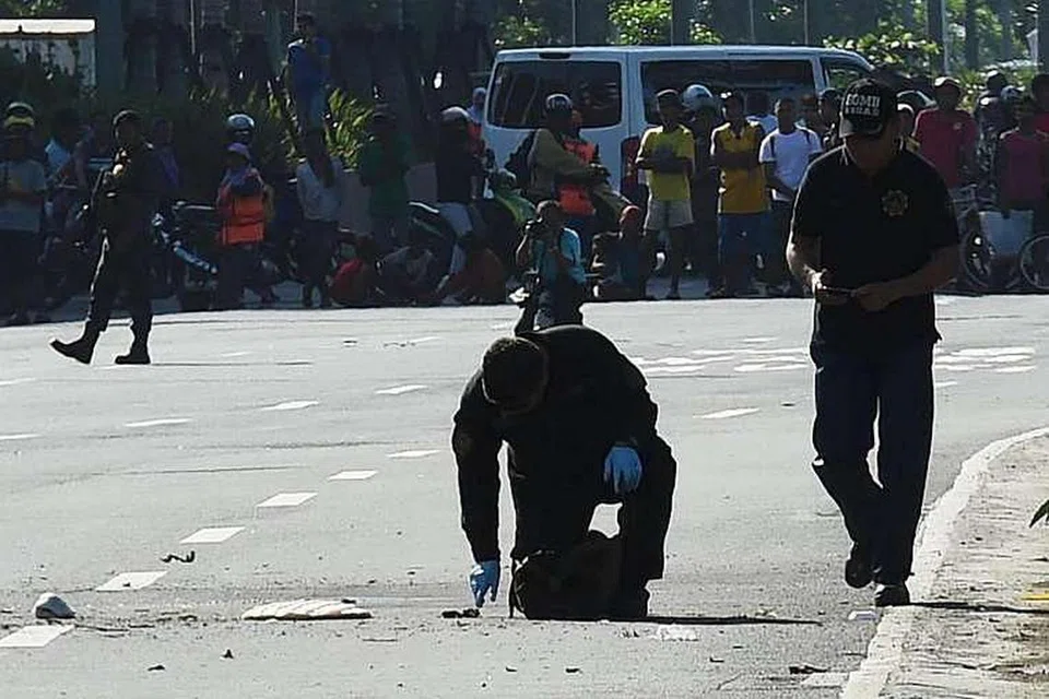 Anggota unit pemusnah bom polis memeriksa bungkisan mencurigakan berhampiran kedutaan Amerika Syarikat di Manila selepas ia diletupkan pada 28 Nov 2016. 