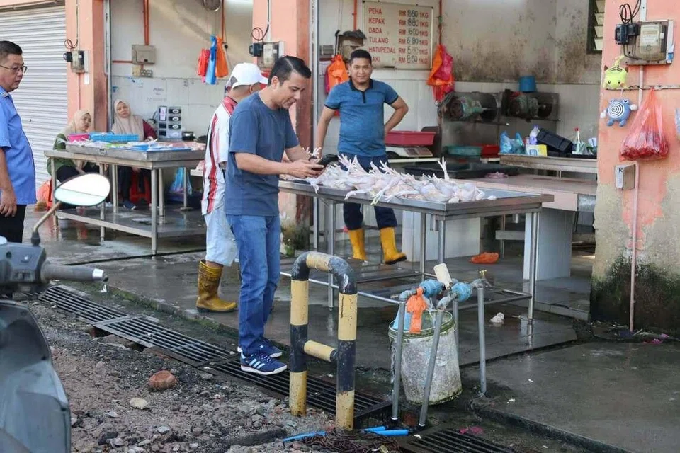 Ahli Dewan Undangan Negeri (Adun) Mahkota, Syed Hussien Syed Abdullah (memegang telefon bimbit), yang dilantik sebagai Timbalan Pengerusi Jawatankuasa Pelaburan, Perdagangan, Hal Ehwal Pengguna dan Sumber Manusia Johor, melawat lokasi longkang tersumbat di Pasar Awam Kluang.