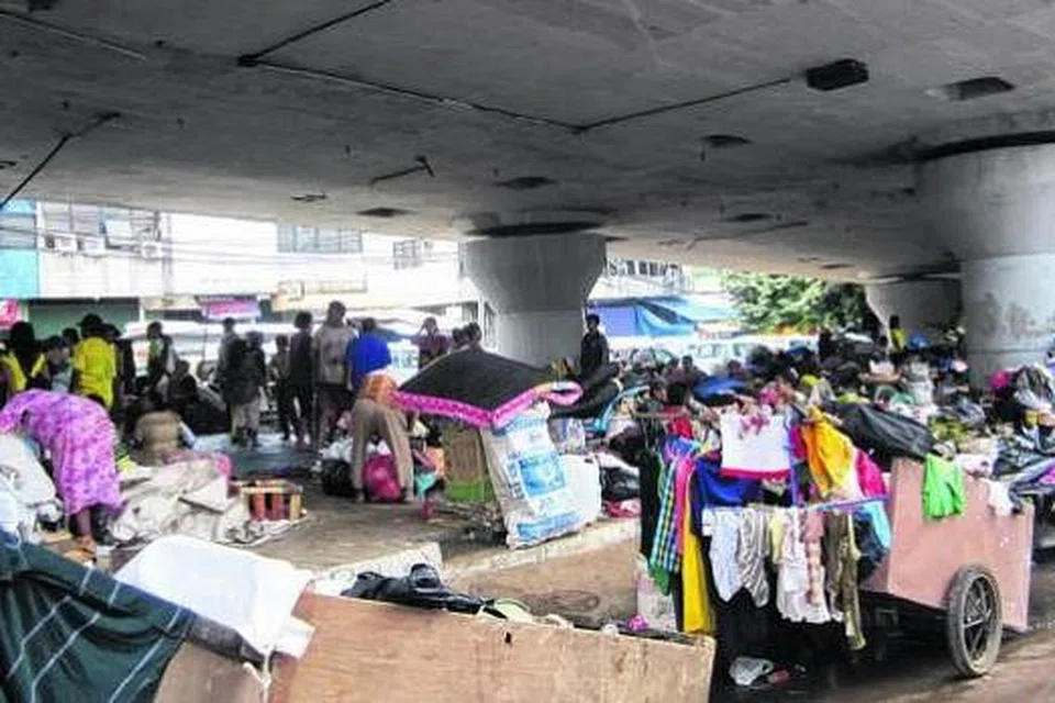MENCARI TEDUH: Berpuluh keluarga dilihat berteduh di bawah jambatan setelah kawasan perumahan mereka dilanda banjir.