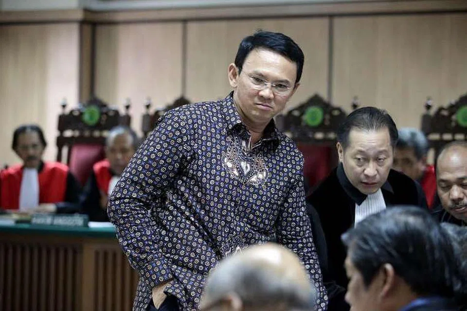 Gabenor Jakarta, Encik Basuki Tjahaja Purnama (tengah), bercakap dengan peguamnya dalam mahkamah semasa perbicaraan pada 27 Dis 2016. 