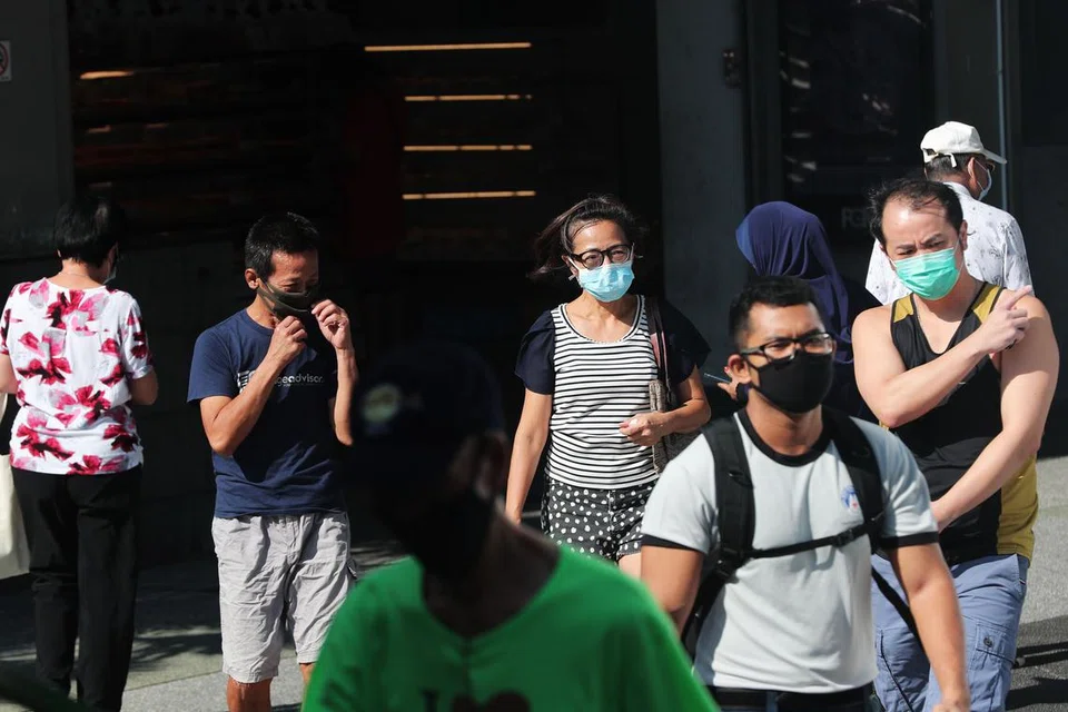 PATUHI PERINTAH: Beberapa orang dilihat memakai pelitup di luar Clementi Mall pada 15 April 2020. - FOTO: KELVIN CHNG