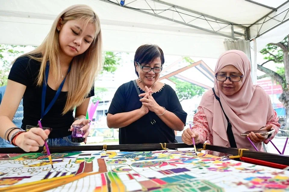 Lukisan batik komuniti sepanjang tiga meter dihasilkan orang ramai di Open Plaza, Wisma Geylang Serai (WGS), bersama penggiat seni tempatan dari Kamal Arts. Ia melambangkan warisan serta kreativiti kolektif.