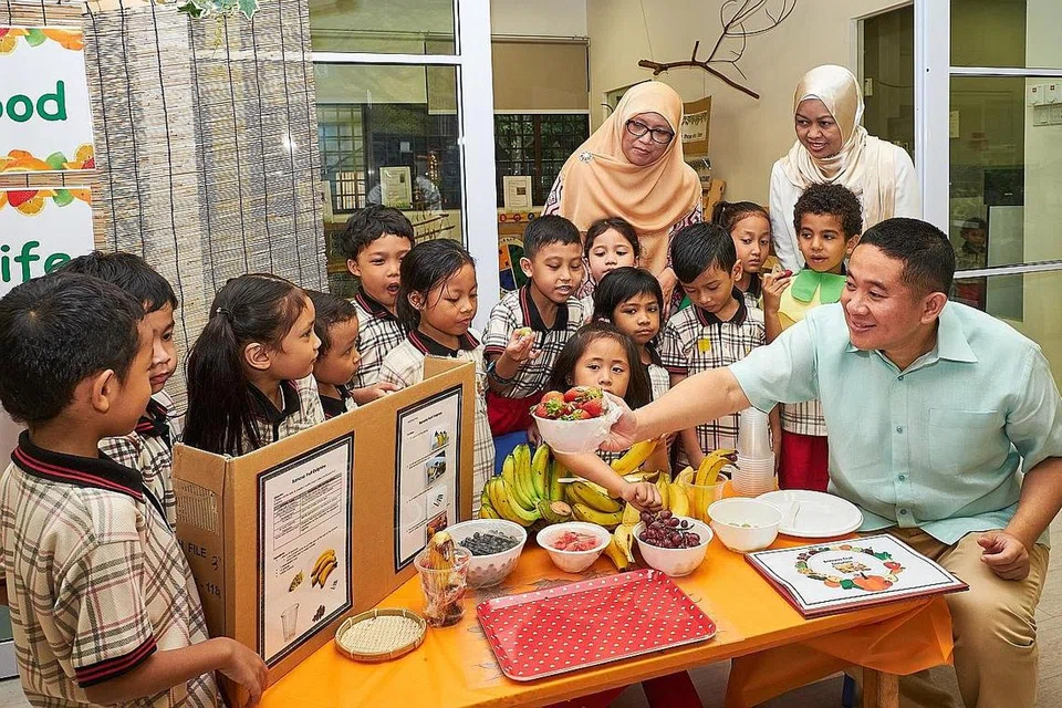 KONGSI KHASIAT MAKANAN: Encik Amrin (kanan) mengongsi beberapa panduan khasiat makanan bersama kanak-kanak PPIS sambil disaksikan Ketua Pegawai Eksekutif (CEO) PPIS, Cik Tuminah Sapawi (kanan, belakang), dan Cik Rahayu (dua dari kanan, belakang). - Foto BH oleh ROSLEE ABDUL RAZAK