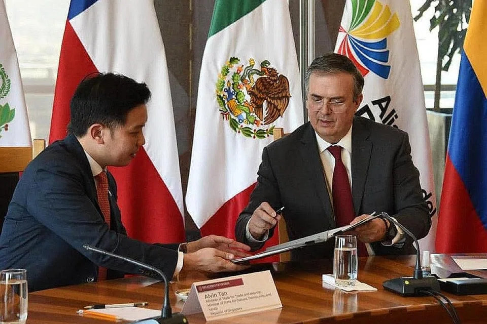 KUKUHKAN EKONOMI: Encik Alvin Tan (kiri) menandatangani persetujuan dengan Encik Marcelo Ebrard bagi memperkukuh ekonomi negara dengan Persekutuan Pasifik. - Foto MARCELO EBRARD/FACEBOOK