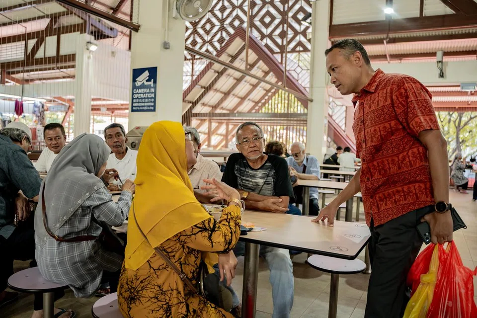 Anggota Parlimen (AP) GRC Marine Parade, Encik Fahmi Aliman (kanan), berinteraksi dengan warga senja semasa bertemu penduduk di Geylang Serai.