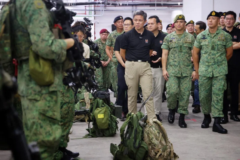 Menteri Pertahanan, Encik Chan Chun Sing (baju hitam, tengah) yang diiringi Menteri Negara Kanan (Pertahanan), Encik Zaqy Mohamad (baju hitam, kanan), dan Menteri Negara (Pertahanan), Encik Desmond Choo (baju hitam, kiri), menemui Pasukan Pengerahan Tentera Darat (ADF) di Kem Nee Soon.
