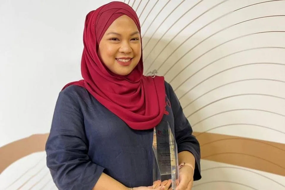 GURU CONTOH: Cik Nur'Aqilah Abdul Malek menerima Anugerah Pendidik Pembangunan Awal Kanak-Kanak Cemerlang di majlis Anugerah Ecda baru-baru ini bagi pengalamannya selama sedekad membangunkan kanak-kanak secara menyeluruh dan kerjasama proaktif bersama ibu bapa untuk mencapai hasil terbaik bagi anak mereka. - Foto NTUC FIRST CAMPUS