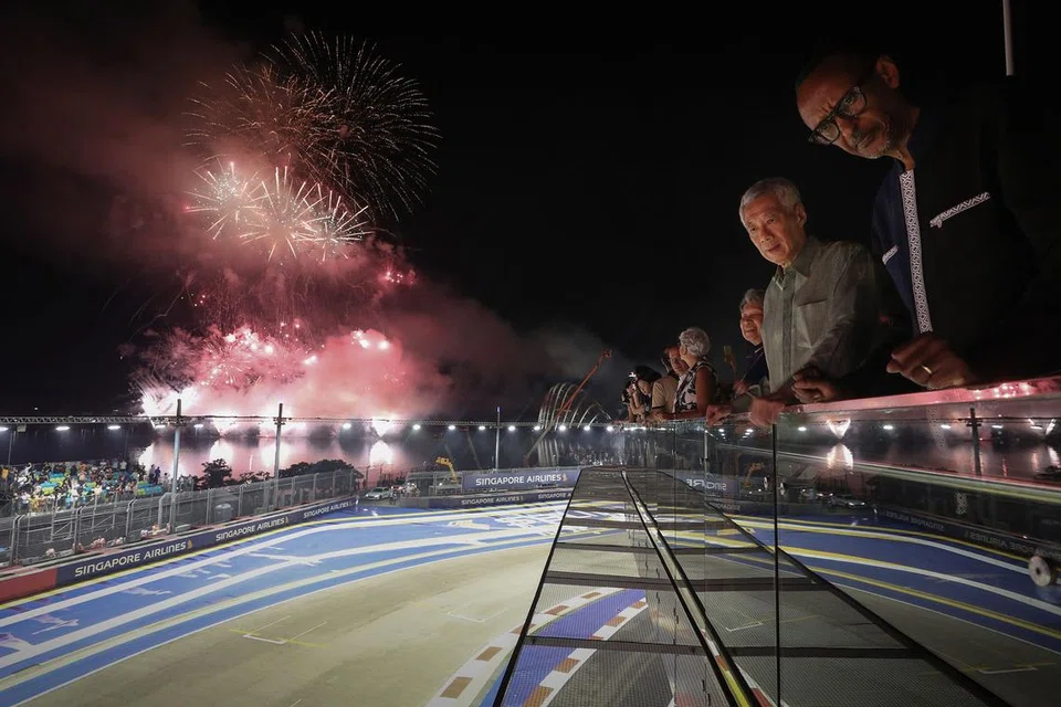 PERTUNJUKAN HEBAT: PM Lee (dua dari kanan) bersama isterinya Cik Ho Ching, dan tetamu lain menikmati pertunjukan bunga api di akhir perlumbaan Grand Prix Singapura kelmarin. - Foto MCI