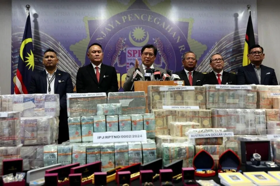 Ketua Pesuruhjaya Suruhanjaya Pencegahan Rasuah Malaysia (SPRM), Tan Sri Azam Baki (tiga dari kiri), menunjukkan wang tunai dan barang kemas yang dirampas dalam siasatan kes terkait mantan Perdana Menteri Malaysia, Datuk Seri Ismail Sabri Yaakob (atas).