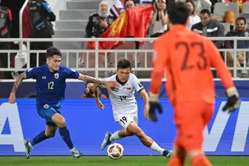 LICIK DAN LINCAH: Beknaz Almazbekov (jersi putih) membawa lari bola daripada pemain Thailand, Look Saa Mickelson dalam perlawanan Kumpulan F antara Kyrgyzstan danThailand di Stadium Abdullah bin Khalifa di Doha. Thailand menang perlawanan itu 2-0. 