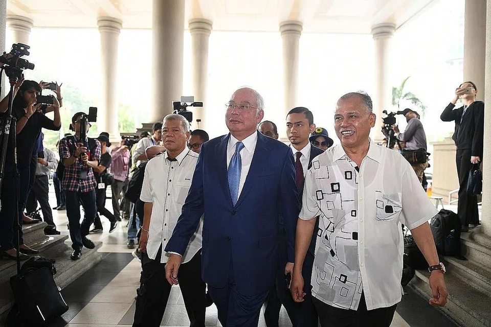 PERBICARAAN BERMULA: Datuk Najib (depan,kiri) tiba di Mahkamah Tinggi di Kuala Lumpur semalam, bagi menghadiri perbicaraan kes 1MDB, di mana beliau dituduh menyeleweng ratusan juta dolar. Kes itu akan dihadapkan lagi ke mahkamah hari ini. - Foto AFP