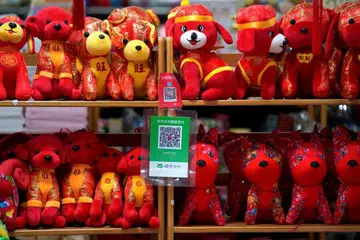 Kod QR bagi Alipay (atas) dan WeChat Pay dipaparkan di kedai mainan di Beijing.