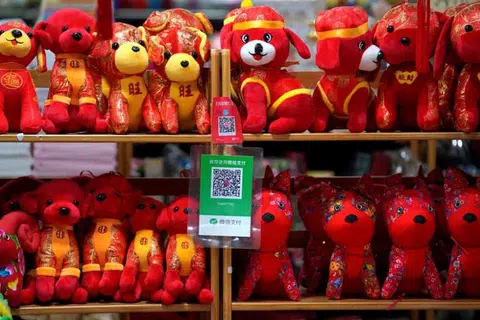 Kod QR bagi Alipay (atas) dan WeChat Pay dipaparkan di kedai mainan di Beijing.