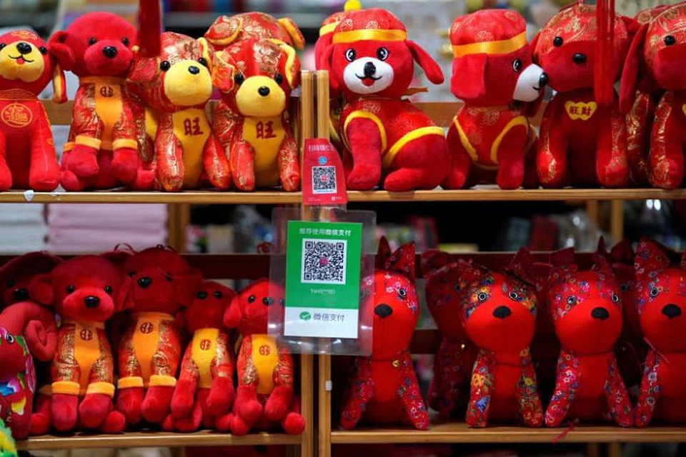 Kod QR bagi Alipay (atas) dan WeChat Pay dipaparkan di kedai mainan di Beijing.