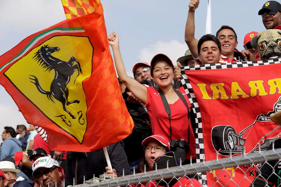 POPULAR DAN DIMINATI DI SERATA DUNIA: Peminat pasukan Ferrari dari Mexico memberikan sorakan kepada pemandu Ferrari sambil menunggu perlumbaan bermula. - Foto REUTERS 