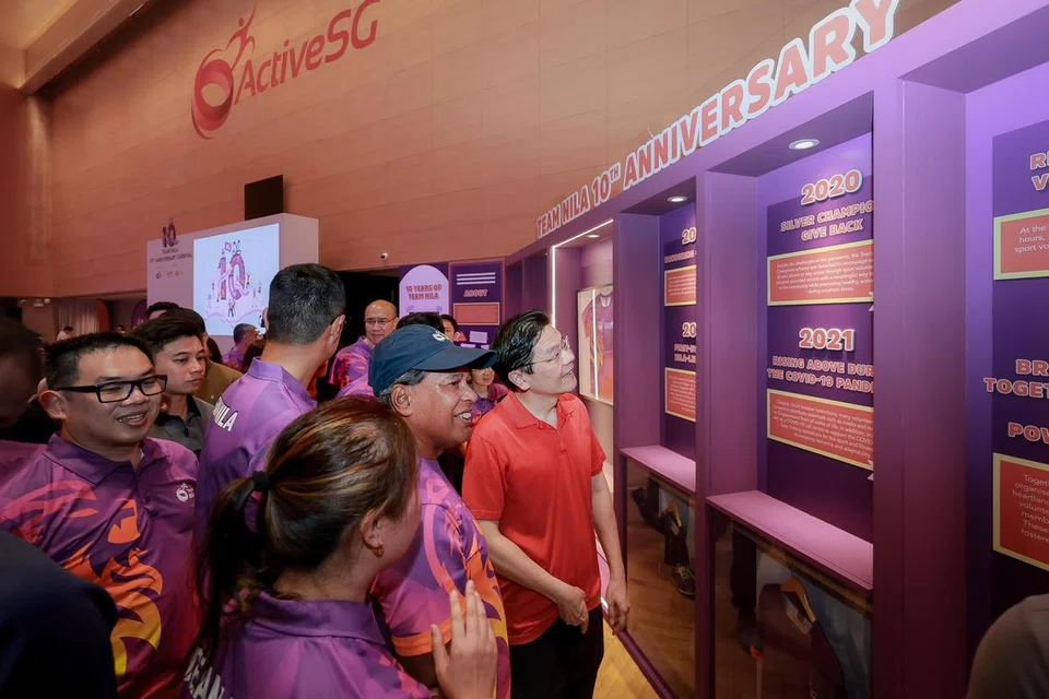 Perdana Menteri Encik Lawrence Wong (kanan) melanggani Pameran Loker Galeri Team Nila. Pameran itu menampilkan gambar sumbangan, kerja keras, dan komitmen Team Nila sepanjang tahun, serta pencapaian penting.