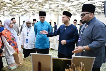 Pemangku Menteri Bertanggungjawab bagi Ehwal Masyarakat Islam, Encik Zaqy Mohamad (dua dari kanan), dan Penolong Pengarah Unit Kandungan dan Bimbingan Agama (RCG) Sektor Satu Masjid (OMS), Ustaz Dr Muhammad Mubarak Habib Mohamed (dua dari kiri), berinteraksi dengan peserta di Perhimpunan Sektor Satu Masjid (OMS) di Safra Choa Chu Kang pada 10 Oktober.