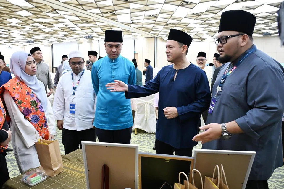 Pemangku Menteri Bertanggungjawab bagi Ehwal Masyarakat Islam, Encik Zaqy Mohamad (dua dari kanan), dan Penolong Pengarah Unit Kandungan dan Bimbingan Agama (RCG) Sektor Satu Masjid (OMS), Ustaz Dr Muhammad Mubarak Habib Mohamed (dua dari kiri), berinteraksi dengan peserta di Perhimpunan Sektor Satu Masjid (OMS) di Safra Choa Chu Kang pada 10 Oktober.