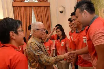 DAPAT PERHATIAN PRESIDEN: Presiden Tony Tan Keng Yam berbual sambil bersalaman dengan dua tekong sepak takraw Team Singapore, Muhammad Danial Feriza Padzli (kanan) dan kapten Mohamad Farhan Amran (di sebelahnya), dalam majlis yang diadakan di Istana petang kelmarin. - Foto THE STRAITS TIMES