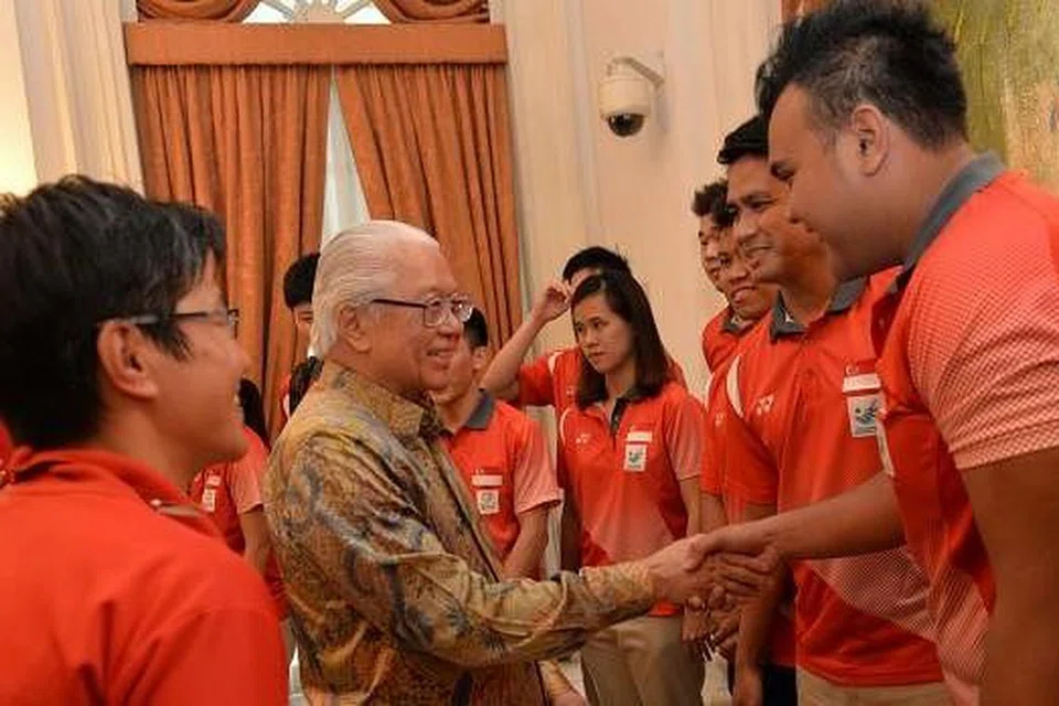 DAPAT PERHATIAN PRESIDEN: Presiden Tony Tan Keng Yam berbual sambil bersalaman dengan dua tekong sepak takraw Team Singapore, Muhammad Danial Feriza Padzli (kanan) dan kapten Mohamad Farhan Amran (di sebelahnya), dalam majlis yang diadakan di Istana petang kelmarin. - Foto THE STRAITS TIMES