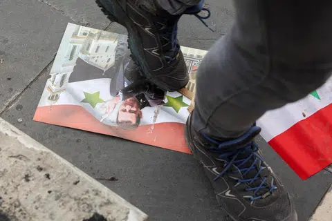 Seorang lelaki memijak gambar mantan Presiden Bashar al-Assad selepas pemberontak menawan ibu kota dan menggulingkannya di Damsyik, Syria, pada 11 Disember.