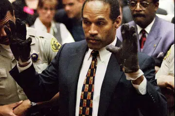 Gambar fail OJ Simpson mencuba sarung tangan, yang ada kesan darah, yang ditemui di lokasi pembunuhan, semasa perbicaraannya. Sarung tangan itu tidak muat dengan tangannya.  
