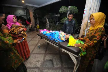TEMPAT SELAMAT: Penduduk memindahkan anggota keluarga di Hospital Larasati di Pamekasan, Indonesia, selepas gempa bumi semalam. - Foto REUTERS