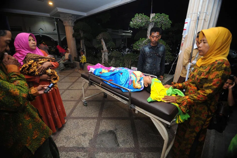 TEMPAT SELAMAT: Penduduk memindahkan anggota keluarga di Hospital Larasati di Pamekasan, Indonesia, selepas gempa bumi semalam. - Foto REUTERS
