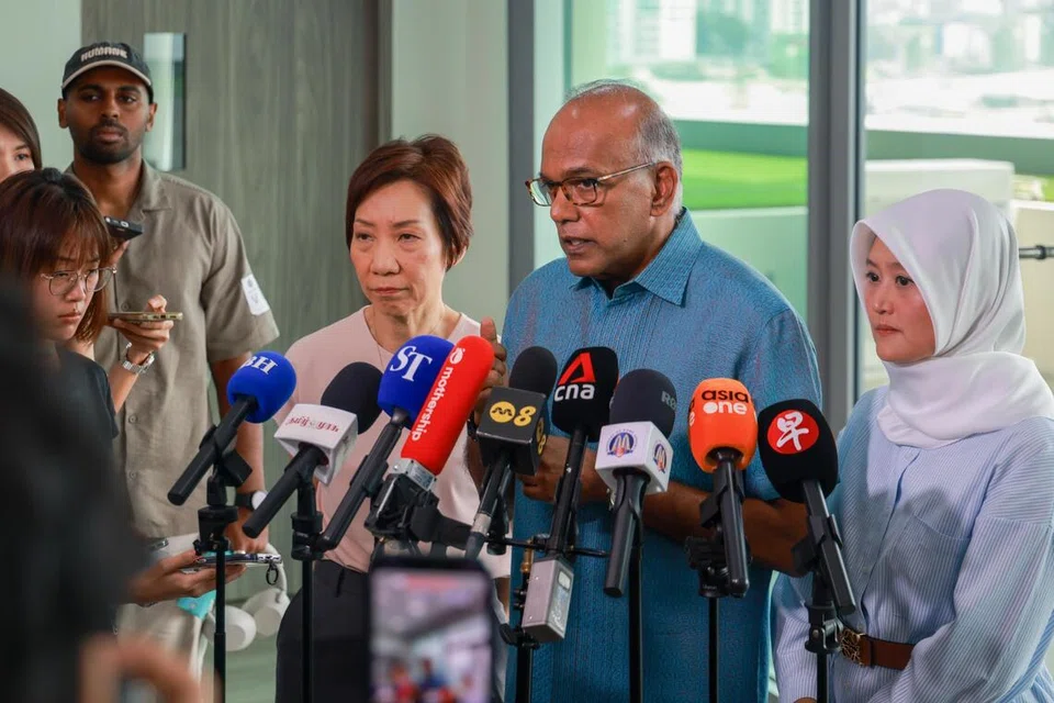 Menteri Kanan merangkap Menteri Ehwal Dalam Negeri, Encik K. Shanmugam (tengah) bertemu pihak media selepas mengunjungi pegawai barisan hadapan di Pusat Pemeriksaan Woodlands pada 19 Oktober. Bersama beliau ialah Menteri Negara (Penerangan dan Pembangunan Digital merangkap Kesihatan), Cik Rahayu Mahzam (kanan) dan Menteri Kemampanan dan Sekitaran, Cik Grace Fu.