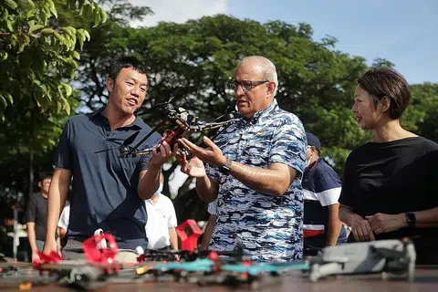 LEBIH SELESA: Encik Iswaran (tengah) sempat melihat salah sebuah dron semasa di kawasan lapang dekat Takungan Air Pandan yang lebih luas dan selesa untuk para penggemar kegiatan tersebut. - Foto BH oleh GIN TAY