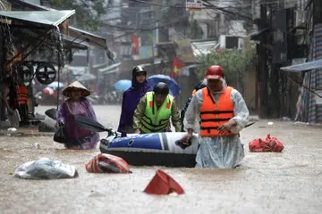 Penduduk menggunakan boya dan sampan untuk berpindah ke tempat lebih selamat ekoran Taufan Yagi yang membawa banjir besar di kawasan utara Vietnam sejak 8 September.