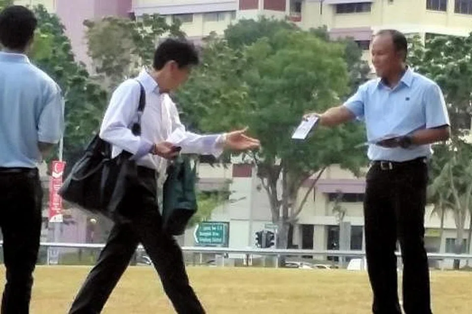 AZAM TERUSKAN KHIDMAT: Encik Muhamad Faisal mengedarkan risalah WP berdekatan stesen MRT Hougang semalam.