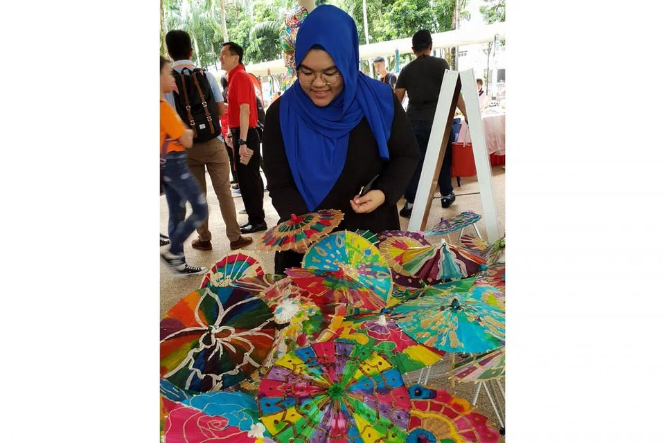 BELI SAMBIL BERAMAL: Cik Nashrah Amirah Mohamed Najib, salah seorang pereka, mencipta acara Payung Batik 1000 dengan payung-payung kecil itu boleh dibeli orang awam. Bagi setiap payung yang dijual, lima kilogram beras akan diberikan kepada orang memerlukan.