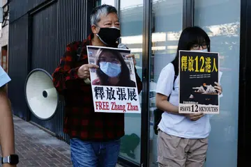 TUNJUK PERASAAN: Penyokong demokrasi mengadakan tunjuk perasaan menggesa China supaya membebaskan 'wartawan warga biasa', Cik Zhang Zhan, dan 12 aktivis Hong Kong. Mereka mengadakan tunjuk perasaan depan pejabat China di Hong Kong Isnin lalu. - Foto REUTERS