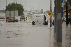 BANJIR: Orang ramai terpaksa meredah banjir buruk yang disebabkan hujan lebat dan taufan Hanna di bandar Saltillo utara Coahuila Mexico semalam. - Foto EPA-EFE