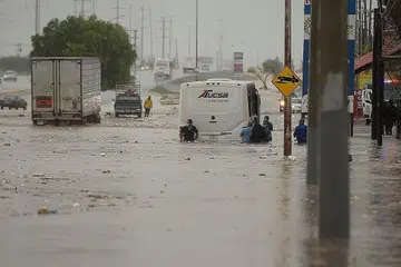BANJIR: Orang ramai terpaksa meredah banjir buruk yang disebabkan hujan lebat dan taufan Hanna di bandar Saltillo utara Coahuila Mexico semalam. - Foto EPA-EFE
