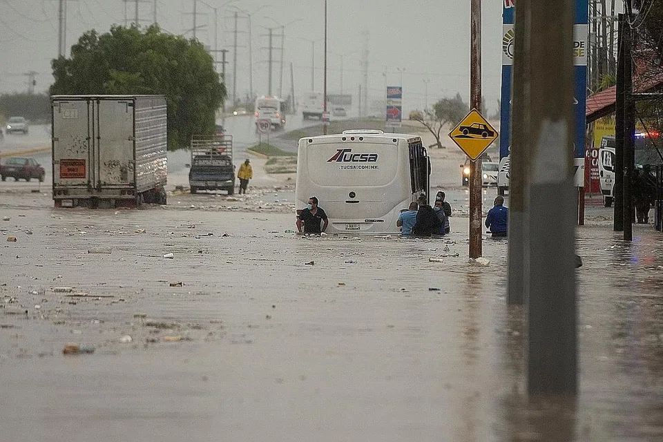 BANJIR: Orang ramai terpaksa meredah banjir buruk yang disebabkan hujan lebat dan taufan Hanna di bandar Saltillo utara Coahuila Mexico semalam. - Foto EPA-EFE