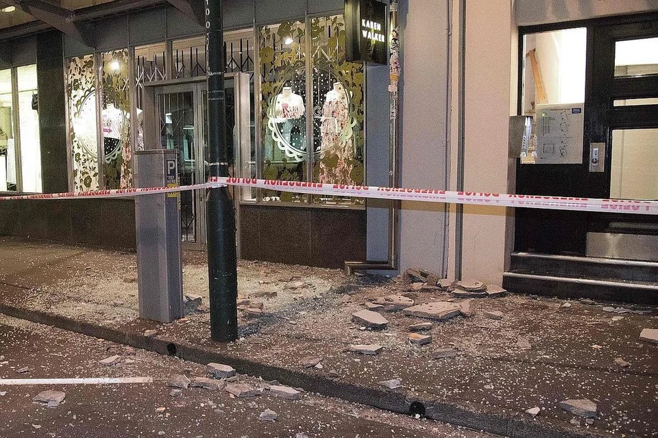 KEROSAKAN KECIL: Serpihan batu-bata dan cermin kelihatan di kaki lima sebuah kawasan di Wellington. - Foto AFP