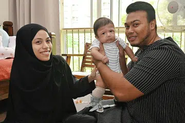 SANGGUP MELAKUKAN APA-APA: Cik Nurul Fateha Abdul Rashid dan Encik Muhammad Nurfahmy Fareed bersama anak mereka, Muhammad Nurfattah Muhammad Nurfahmy yang menghidap Arthrogryposis Multiplex Congenita (AMC) jenis 2B dan beberapa kekurangan ciri jantung, dada dan paru-paru. - Foto-foto BH oleh KHALID BABA